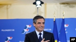 FILE - Francois Fillon puts his hand on his heart after delivering a speech following the conservative presidential primary, in Paris, France, Nov. 27, 2016.