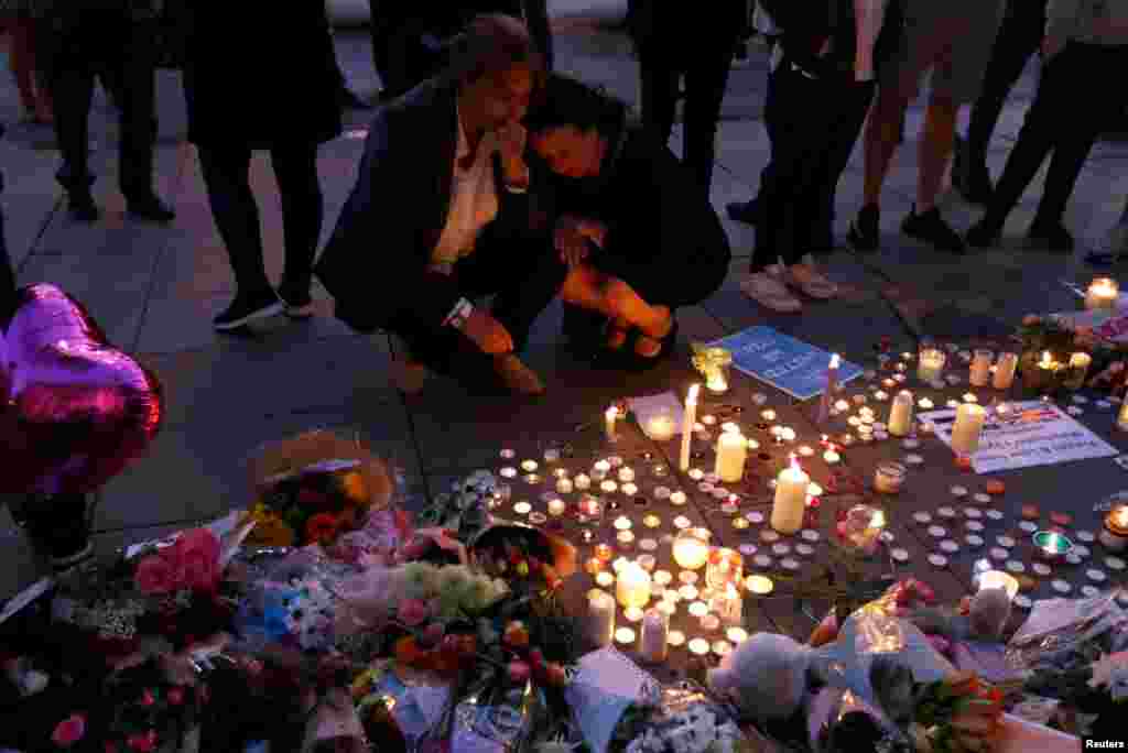 Women pay their respects to all those affected by the bomb attack, following a vigil in central Manchester, Britain, May 23, 2017.