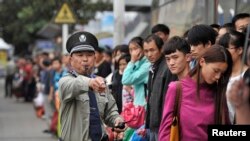 FILE - A security guard blows a whistle at a bus stop outside a railway station Hefei, Anhui province during a busy time, Oct. 7, 2013. (Reuters photo)