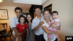 Reuters journalist Wa Lone (right) with wife Pan Ei Mon and daughter along with colleague Kyaw Soe Oo (left) carrying his daughter and his wife Chit Su Win. (AFP)