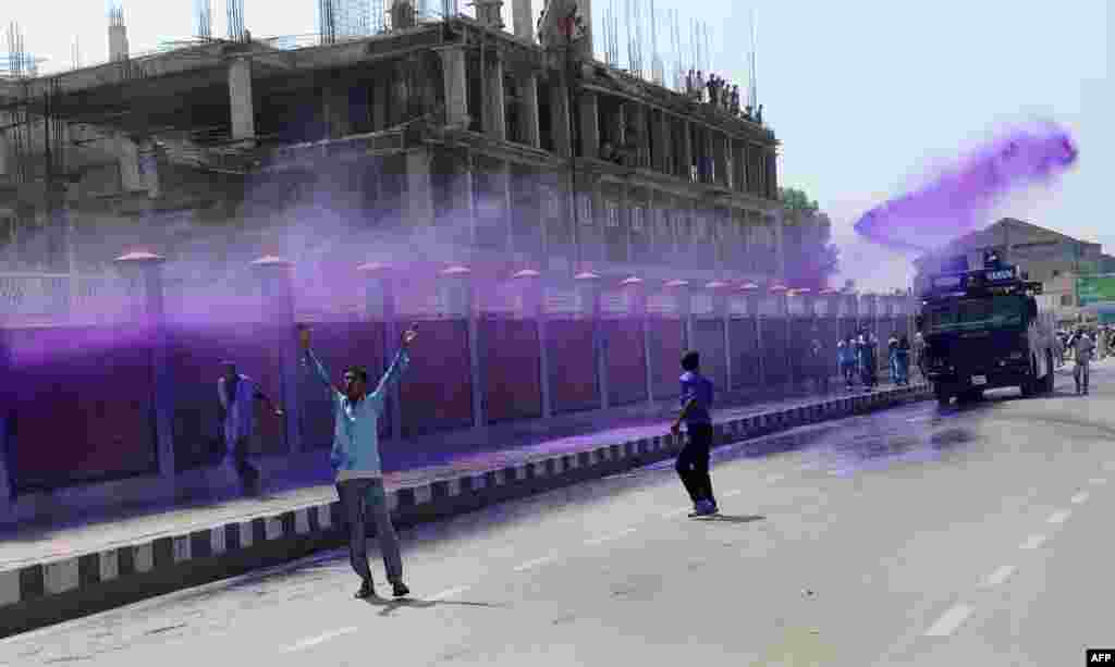 Pegawai pemerintah Kashmir disemprot dengan air berwarna ungu oleh polisi anti huru hara selama demonstrasi di Srinagar, Kashmir-India.