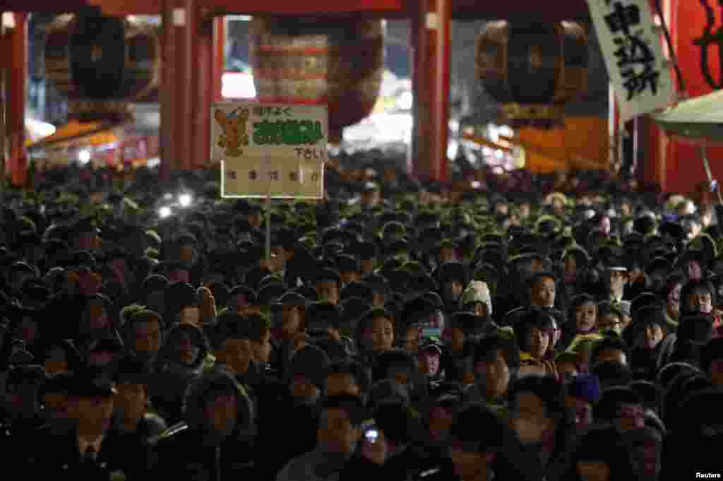 People stand in line to offer new year prayers at Sensoji temple, Tokyo, Japan, Jan. 1, 2014. 