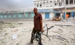 FILE - A Somali journalist holds his camera after he was injured in an explosion in front of Dayah hotel in Somalia's capital Mogadishu, Jan. 25, 2017.