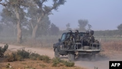 FILE - Members of the Cameroonian Rapid Intervention Force patrol on the outskirts of Mosogo in the Far North region of the country where Boko Haram jihadist have been active for years, March 21, 2019.