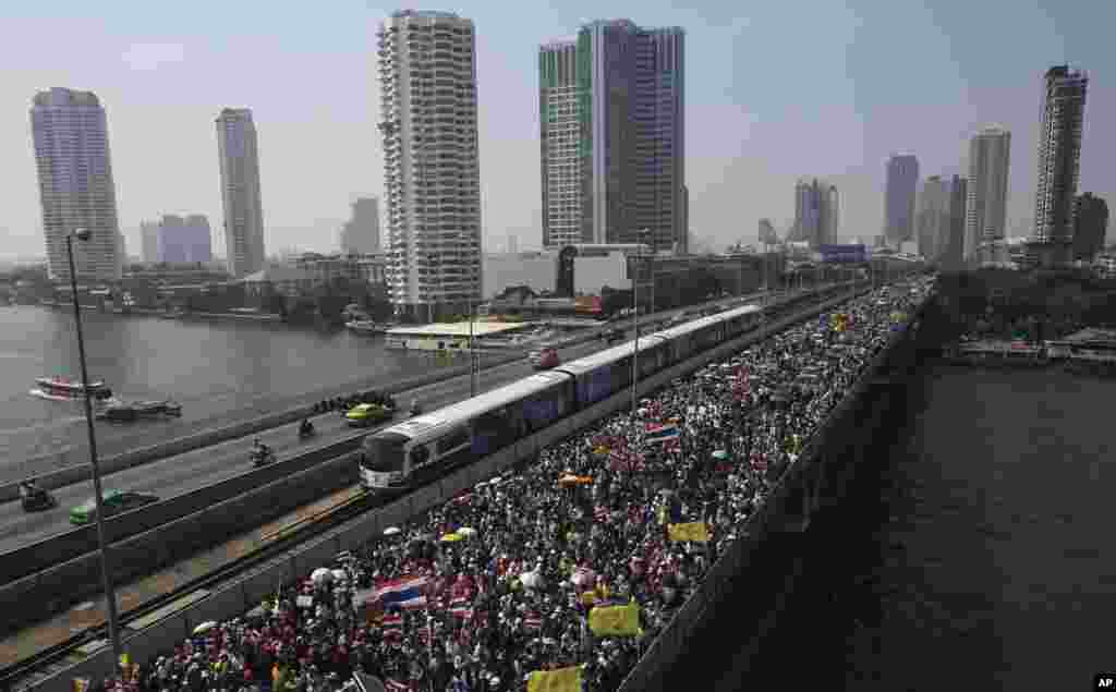 Thai anti-government protesters march cross Takin Bridge during a rally, Dec. 22, 2013, in Bangkok, Thailand. 