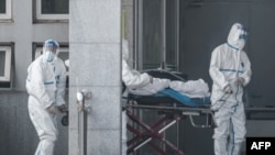中国湖北省武汉市收治新型冠状病毒肺炎病人的金银潭医院医务人员在运送一名病人。（2020年1月18日）