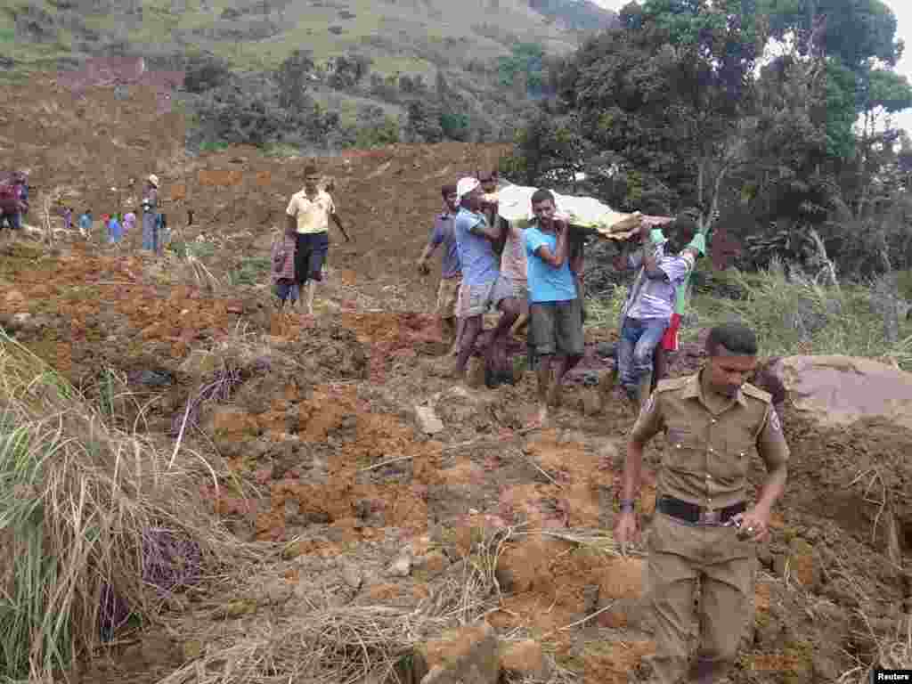 Villagers carry the body of a landslide victim at the Koslanda tea plantation in Badulla, about 220 kilometers east of Colombo, Sri Lanka, Oct. 29, 2014.