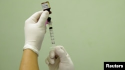 FILE - A health agent prepares a vaccine during a campaign of vaccination against yellow fever in Rio de Janeiro, Brazil, March 25, 2017.