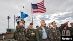 Menteri Pertahanan Korea Selatan Kim Kwan-jin (kanan) menunjukkan arah wilayah Korea Utara kepada Menhan AS Chuck Hagel saat meninjau Zona Demiliterirasi (DMZ) yang memisahkan kedua Korea, Senin (30/9).