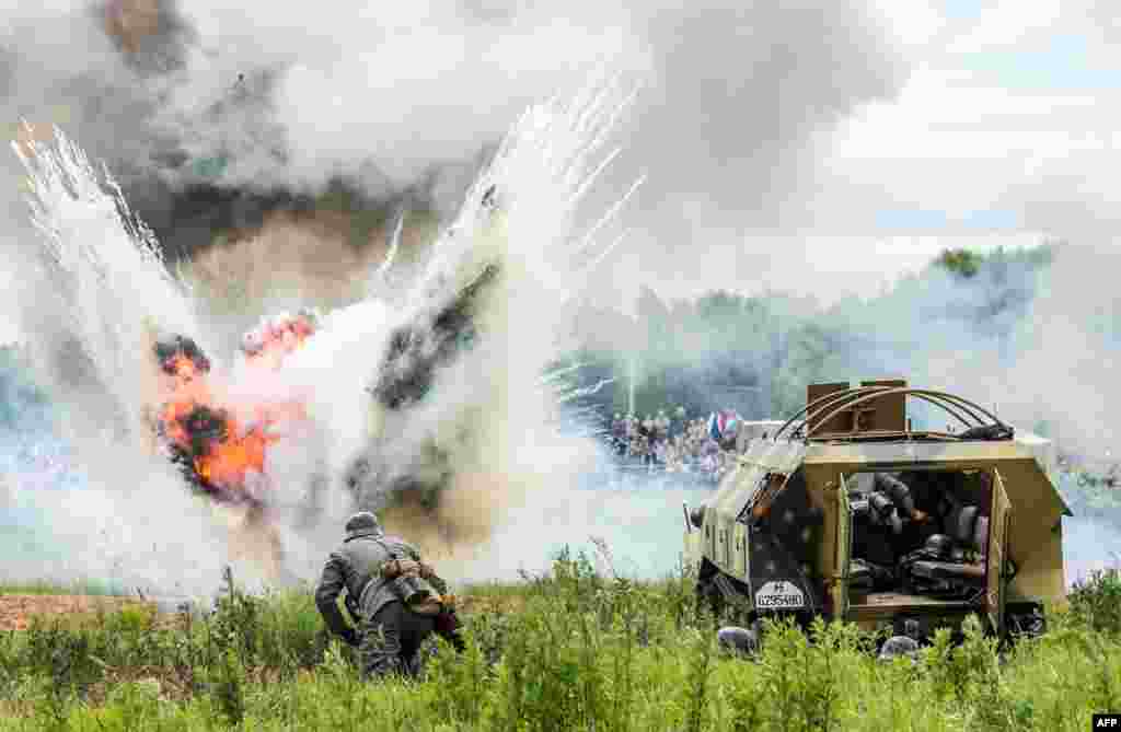 Military history enthusiasts dressed as Germany Nazi troops take part in the staged battle "Summer 1941" near the village of Ivanovskoye, some 60 km outside Moscow, Russia, during the "War of Motors 2014" Festival marking the 73rd anniversary of the Nazi invasion of the Soviet Union.