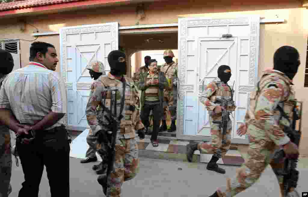 Pakistani paramilitary troops raid the Muttahida Quami Movement's offices in Karachi, March 11, 2015.
