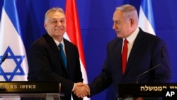 ARCHIVO - El primer ministro húngaro Viktor Orban, a la izquierda, saluda al primer ministro israelí Benjamin Netanyahu en Jerusalén, el 19 de febrero de 2019.