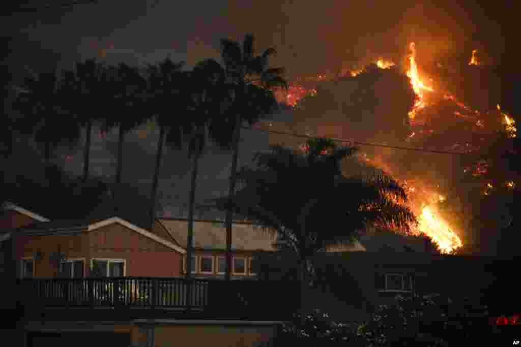 A wildfire threatens homes as it burns along a hillside in La Conchita, California, Dec. 7, 2017.