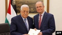 Presiden Palestina Mahmud Abbas (kiri) berposes bersama perdana Menteri Palestina yang baru Mohammad Mustafa, di Ramallah, pada 14 Maret 2024. (Foto: AFP/HO/PPO)