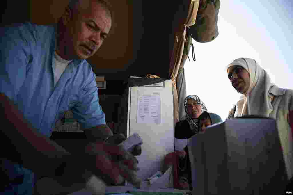 Syrian refugees wait to fill prescriptions at a pharmacy at a Moroccan-run field hospital at the Za'tari refugee camp. (Y. Weeks/VOA)