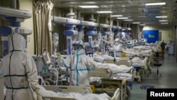 Petugas medis mengenakan pakaian pelindung khusus tengah menangani pasien di bangsal ICU sebuah rumah sakit di Wuhan, Hubei, China, 6 Februari 2020.