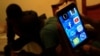 A Sudanese man holds his phone with restricted internet access to social media platforms, in Khartoum, Jan. 1, 2019. 