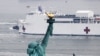 Kapal Rumah Sakit USNS Comfort melintas di depan Patung Liberty saat memasuki Pelabuhan New York di tengah wabah virus corona (COVID-19) di Kota New York, 30 Maret 2020. (Foto: Reuters)