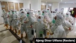 Petugas kesehatan yang mengenakan alat pelindung diri (APD) bersiap untuk merawat pasien di rumah sakit darurat COVID-19 di Wisma Atlet, Jakarta, 26 Januari 2021. (Foto: Reuters/Ajeng Dinar Ulfiana)