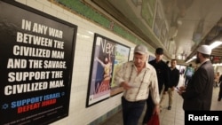 Cyrus McGoldrick, a member of the Council on American-Islamic Relations, talks to commuters as they walk by an advertisement that reads "Support Israel/Defeat Jihad" in the Times Square subway station in New York, September 24, 2012.