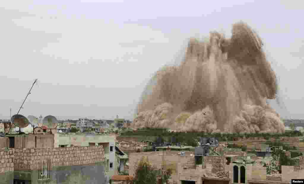 Debris rises in what the Free Syrian Army fighters and Islamic rebels said was an operation to strike the Al-Sahaba checkpoint, which is considered a gateway to Al-Dayf valley, and remove forces loyal to Syria's President Bashar Al-Assad in Maarat Al-Nouman, Idlib province, May 5, 2014.