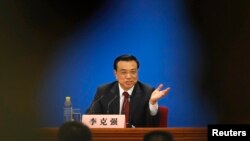 China's newly-elected Premier Li Keqiang gestures during his news conference in Beijing, March 17, 2013.
