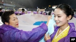 지난 2006년 6월 한국 광주 월드컵경기장에서 열린 6.15 공동선언 기념 남북공동행사에서 한국 참가자(왼쪽)가 북한에서 온 참가자의 얼굴에 묻은 빗물을 닦아주고 있다.