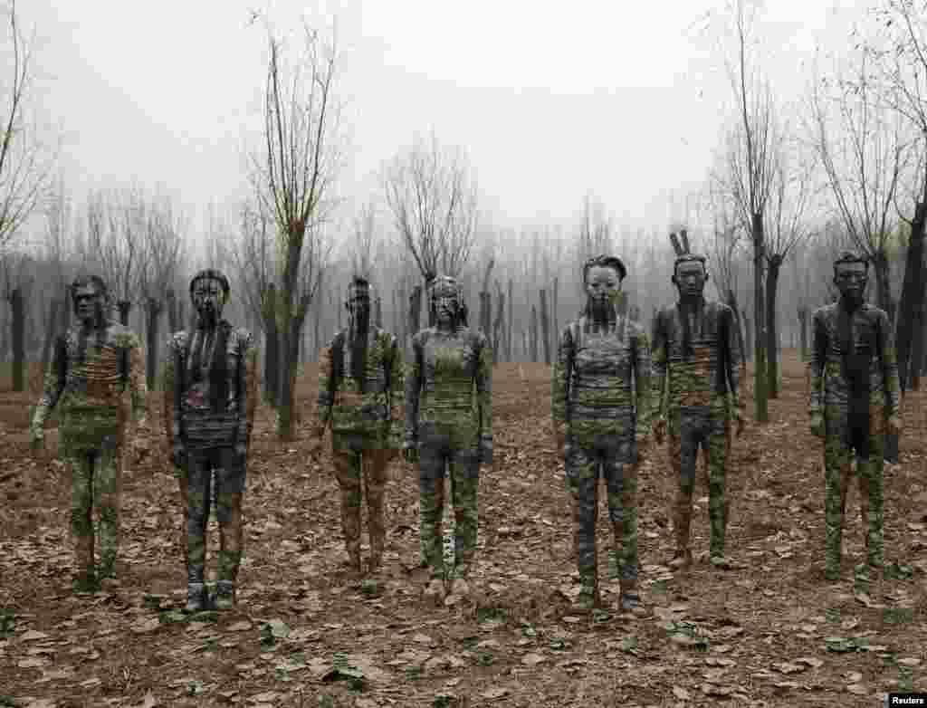 Models painted in camouflage colors to blend in with the background pose for Chinese artist Liu Bolin's artwork "Dongji", or Winter Solstice, in Beijing. In this artwork, Liu wants to express his concerns about China and its people, including air pollution problem, he told Reuters.