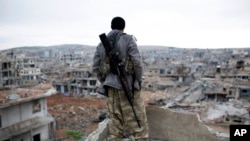 FILE - A Syrian Kurdish sniper looks at the rubble in the Syrian city of Kobani.
