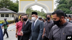Malaysia opposition leaders Anwar Ibrahim, center, and Lim Guan Eng, left, leave National Palace after meeting the King in Kuala Lumpur, Aug. 17, 2021.