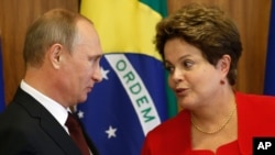 Russia's President Vladimir Putin, left, listens to Brazil's President Dilma Rousseff during a signing ceremony at Planalto presidential palace in Brasilia, Brazil, Monday, July 14, 2014.