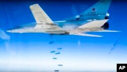 Image d'archives: Un bombardier russe Tu-22M3 largue des bombes sur une cible comme le montre cette photo réalisée à partir d'images vidéo fournies par le ministère russe de la Défense, le 9 décembre 2015.