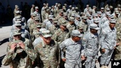 FILE - Arizona National Guard soldiers line up as they get ready for a visit from Arizona Gov. Doug Ducey prior their deployment to the Mexico border at the Papago Park Military Reservation, April 9, 2018, in Phoenix.