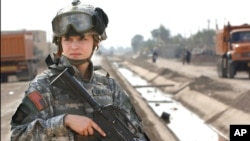 FILE - U.S. soldier Pfc. Janelle Zalkovsky, from civil affairs unit of 1st Battalion, 320th Field Artillery Regiment, 101st Airborne Division, provides security while other soldiers survey a newly constructed road in Ibriam Jaffes, Iraq.