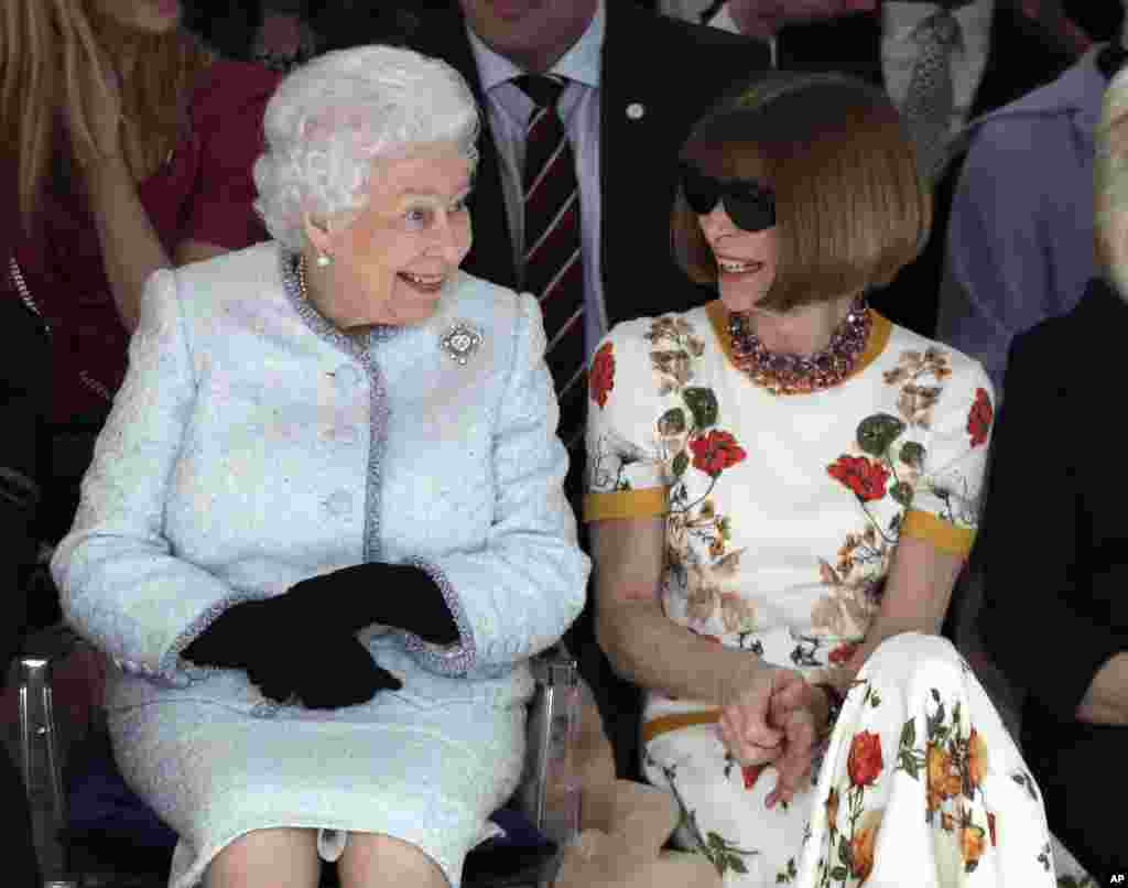 Britain's Queen Elizabeth sits next to fashion editor Anna Wintour as they view Richard Quinn's runway show before presenting him with the inaugural Queen Elizabeth II Award for British Design, during her visit to London Fashion Week's BFC Show Space in London.