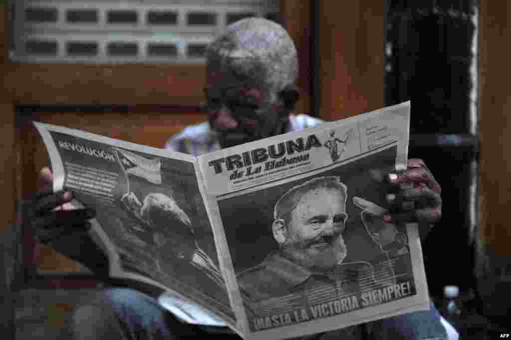A man reads a newspaper in a street of Havana two days after Cuban revolutionary leader Fidel Castro died.