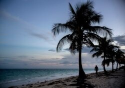 A woman walks along a beach before the arrival of Hurricane Dorian in Freeport, Grand Bahama, Bahamas, Aug. 31, 2019.