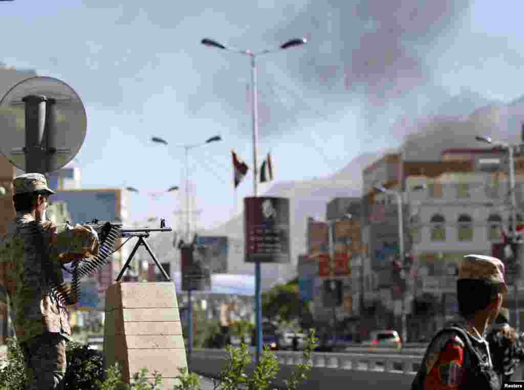 A soldier mans a machine gun along a road leading to the Defense Ministry compound after an attack in Sana'a, Dec. 5, 2013.