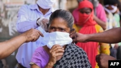 Watu wa Dayosisi ya Kanisa la Amritsar Kaskazini mwa India wakigawa maski kwa wananchi wakati serikali ya India ilipotangaza amri ya kutotoka nje kudhibiti janga la corona Aprili 15, 2020. (Photo by NARINDER…