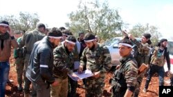 Des combattants de l'armée libre de Syrie libre soutenus par la Turquie dans le village de Der Mismis au sud-est d'Afrine, en Syrie, le 13 mars 2018. (Hasan Kirmizitas / DHA-Depo Photos via AP)