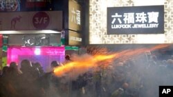 Policemen fire tear gas shells toward protesters at a shopping district of Hong Kong, Aug. 31, 2019.