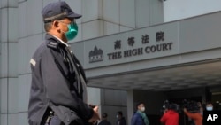 Seorang polisi berjaga di depan Pengadilan Tinggi Hong Kong, 18 Februari 2021. (AP Photo/Vincent Yu)