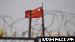 资料照：新疆喀什南部的一个营地高墙铁丝网后的中国国旗。（2019年6月4日）