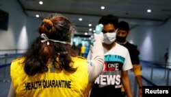 Health Quarantine officer checks people with a thermal scanner after Indonesia confirmed its first cases of coronavirus disease (COVID-19), in Soekarno Hatta International Airport, in Tangerang near Jakarta, Indonesia, March 6, 2020.
