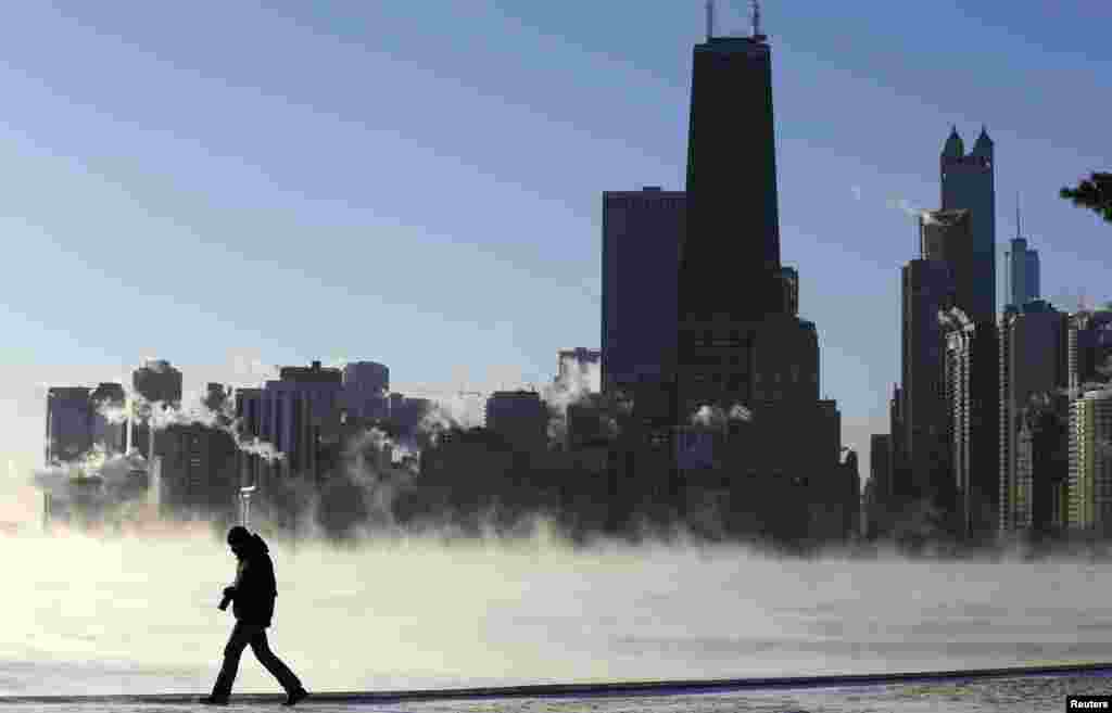 A man is silhouetted against the arctic sea smoke rising off Lake Michigan in Chicago, Illinois, Jan. 6, 2014.