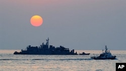 A South Korean goverment ship (R) sails by Navy MSB (Movement Sea Base) off the South Korea-controlled island of Yeonpyeong near the disputed waters of the Yellow Sea, 22 Dec 2010