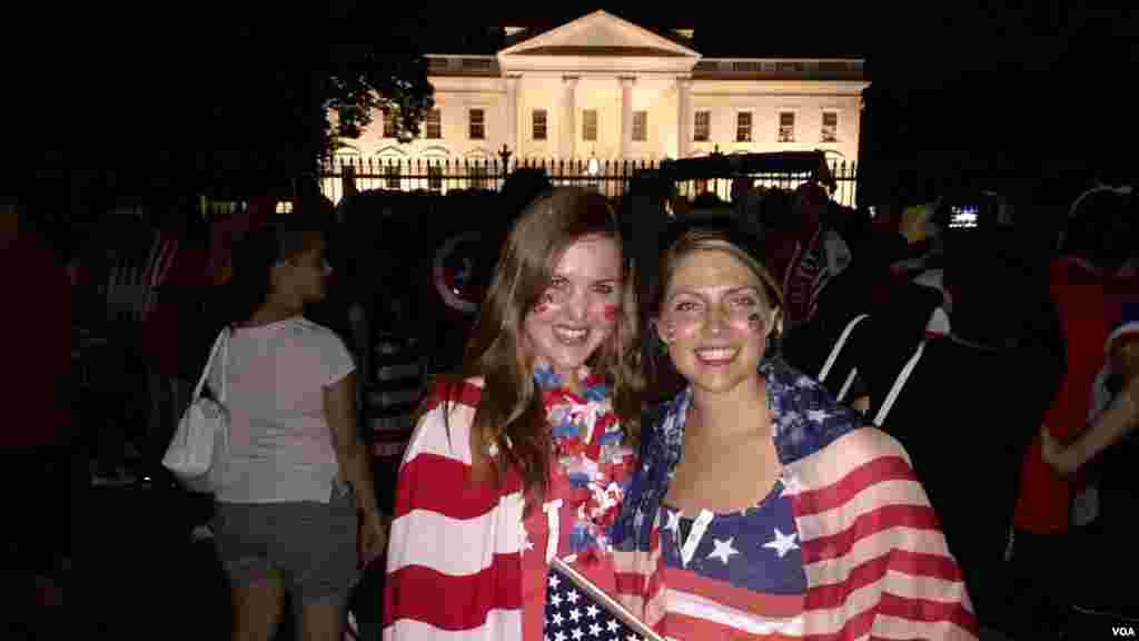 Devant la Maison Blanche à Washington, Laura Neff de Californie (à gauche) et Kayli Westling du Wyoming (à droite), célèbrent le sacre de l’équipe nationale américaine de football féminin (American Outlaws) après la victoire 5-2 sur le Japon le 5 juillet 2015.