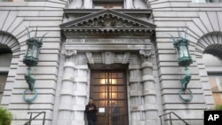 FILE - A man stands outside the main door of the 9th U.S. Circuit Court of Appeals building in San Francisco, Feb. 9, 2017.