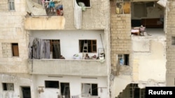 Children stand on a balcony of a damaged building at a site hit at dawn by an airstrike in the rebel-controlled town of Ariha in Idlib province, Syria, Feb. 27, 2017.