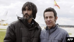 El Mundo correspondent Javier Espinosa (R) and freelance photographer Ricardo Garcia Vilanova arrive at the military airbase in Torrejon de Ardoz, near Madrid, March 30, 2014. 